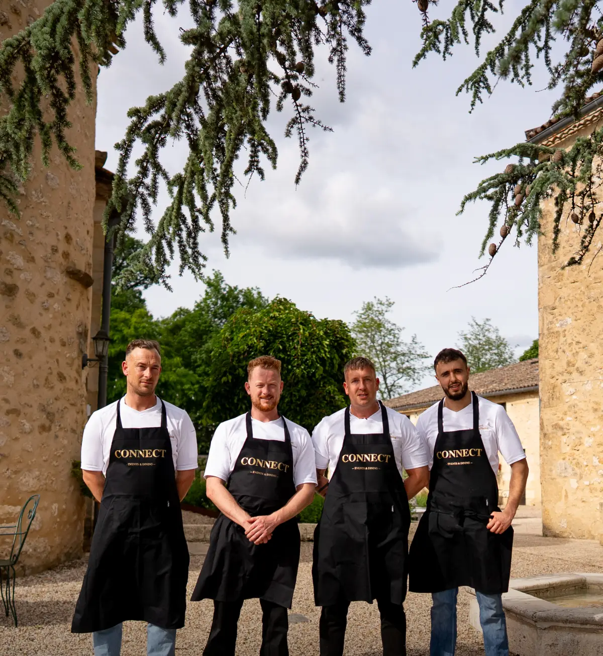 Het team van Connect Events & Dining in zwarte schorten op het landgoed van Château de Sanse