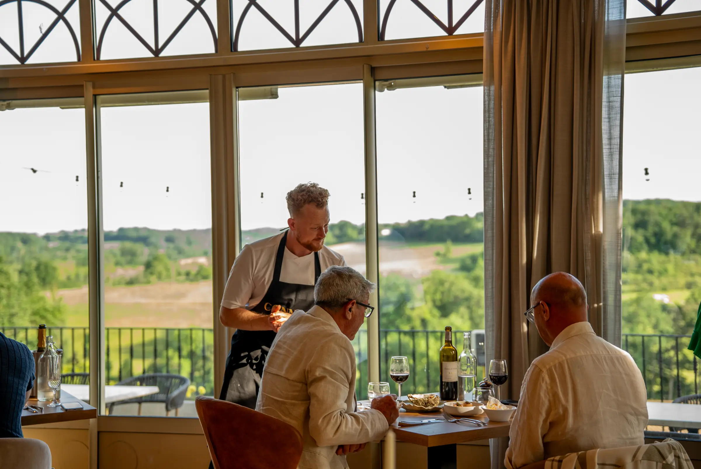 Onze chef serveert aan tafel op Château de Sanse, met uitzicht over de wijngaarden