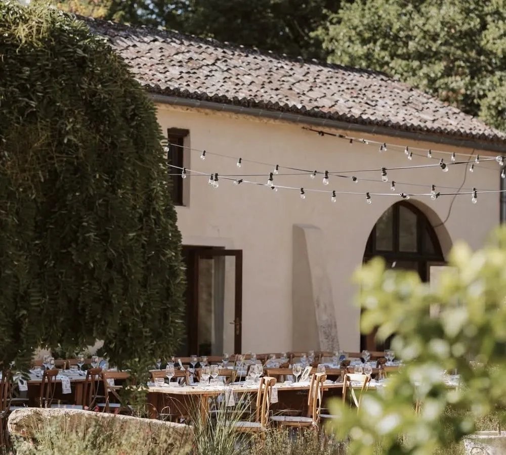 Het terras van Château de Sanse met lange tafels, gedekt voor het bruiloftsdiner